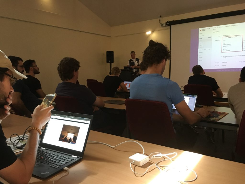 A group take notes while Vladimir Roudakov gives a talk on Gitlab